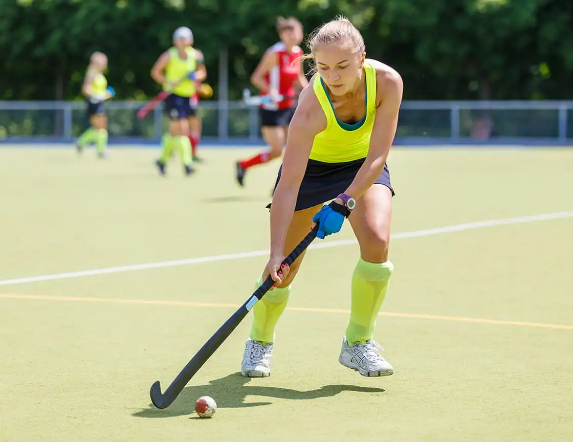 An adult women on a field hockey team.