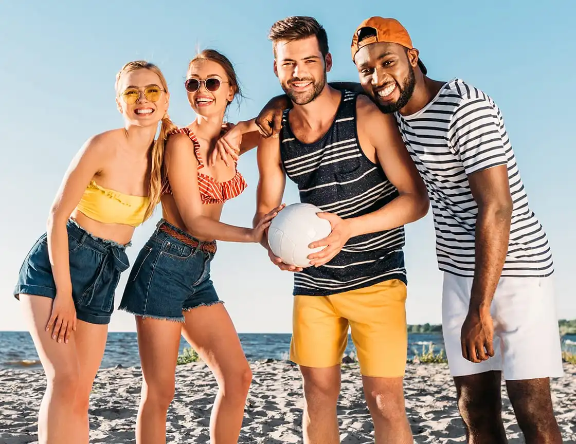 A team of adult men and women on a volleyball team.